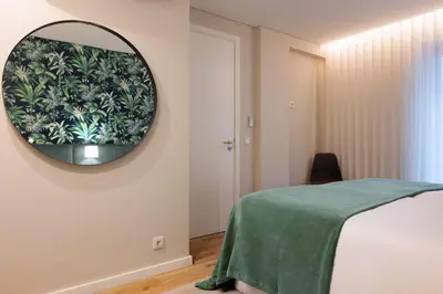 a bedroom with a mirror and a bed with a green blanket at Byobu Apartment, by Bolhão Residences in Porto