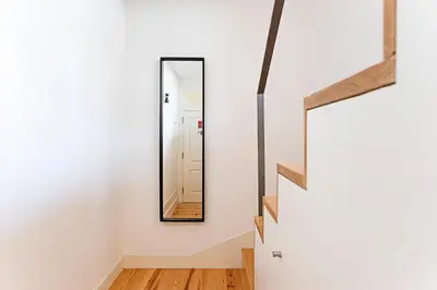 a mirror on the wall next to a staircase in a house at D. João IV Apartments by LovelyStay in Porto