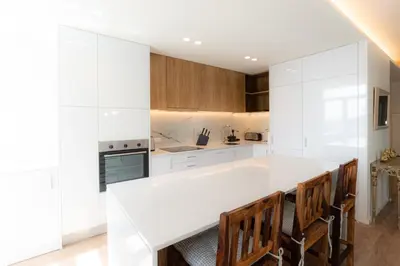 a kitchen with a white counter and wooden cabinets at Alegria Porto by We Do Living in Porto