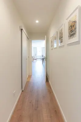 an empty hallway with white walls and wood floors at Alegria Porto by We Do Living in Porto
