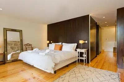 a bedroom with a large white bed and a mirror at Boutique Rentals- Hidden Garden Porto's downtown in Porto