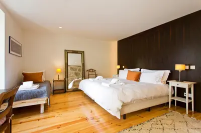a bedroom with a large bed and a mirror at Boutique Rentals- Hidden Garden Porto's downtown in Porto