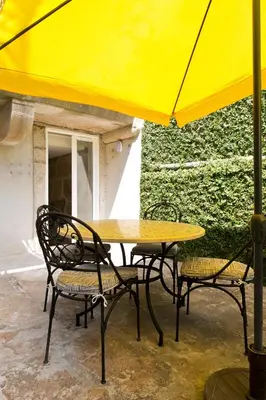 a table and chairs under a yellow umbrella at Boutique Rentals- Hidden Garden Porto's downtown in Porto