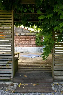 a wooden porch with a bench and a brick wall at Boutique Rentals- Hidden Garden Porto's downtown in Porto