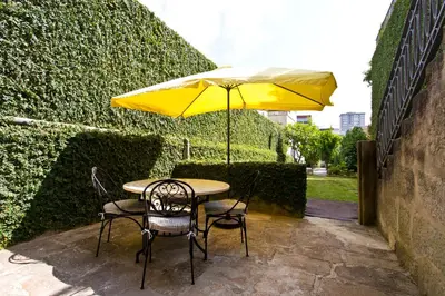 a table and chairs with a yellow umbrella at Boutique Rentals- Hidden Garden Porto's downtown in Porto