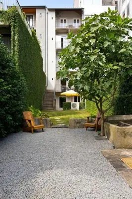 two benches and a tree in front of a building at Boutique Rentals- Hidden Garden Porto's downtown in Porto