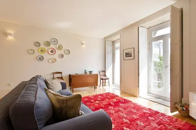 a living room with a blue couch and a red rug at Boutique Rentals- Hidden Garden Porto's downtown in Porto