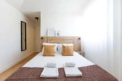 a bedroom with a large white bed with two pillows at Aliados Premium 1BR w/ Terrace by LovelyStay in Porto