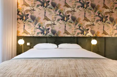 a bedroom with a large bed with a floral wallpaper at Savannah Apartment, by Bolhão Residences in Porto