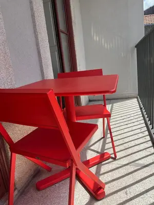 a red table and a red chair on a balcony at CASA SANTO ILDEFONSO in Porto
