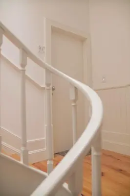 a white spiral staircase in a room with a door at CASA SANTO ILDEFONSO in Porto