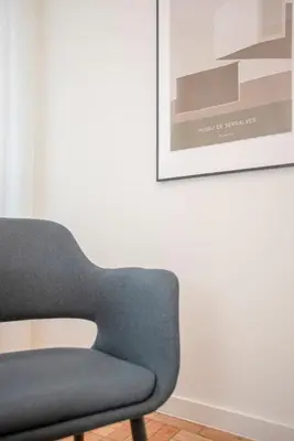 a blue chair sitting in a room with a picture at Liiiving in Porto - Design Bright House in Porto