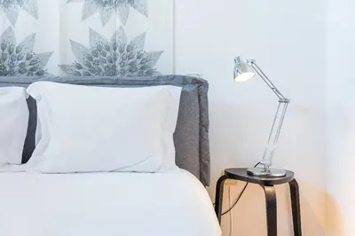 a lamp sitting on a table next to a bed at Dream Views of Porto - Private Apt in Gaia by Lisbeyond in Vila Nova de Gaia
