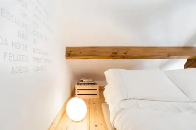 a small bedroom with a bed and a wooden floor at Studio Duplex w/ AC In Praça República by LovelyStay in Porto