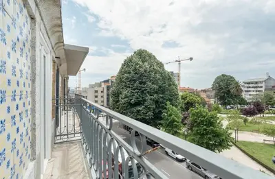 a balcony of a building with trees in the background at Studio Duplex w/ AC In Praça República by LovelyStay in Porto