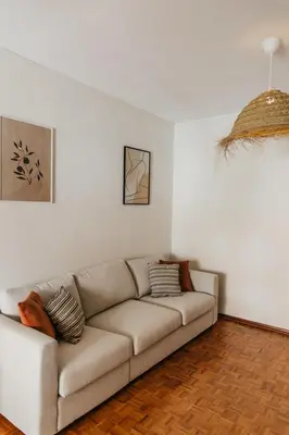 a living room with a couch in a white room at Apartamento Santos Pousada in Porto