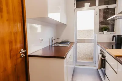 a small kitchen with a sink and a window at Apartamento Santos Pousada in Porto