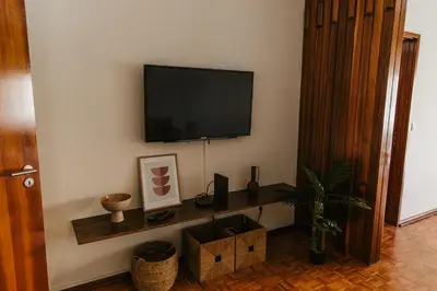 a living room with a flat screen tv on a wall at Apartamento Santos Pousada in Porto