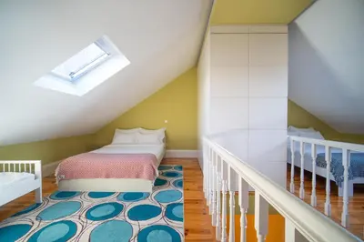 a attic bedroom with a bed and a staircase at Near Boavista - Free Parking in Porto