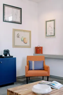 a living room with an orange chair and a table at The Editory Artist Baixa Porto Hotel in Porto
