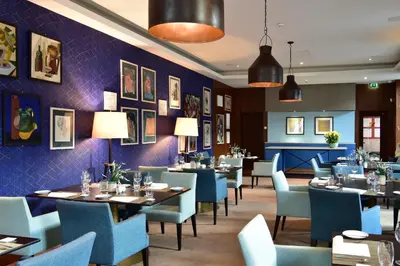 a restaurant with tables and chairs and purple walls at The Editory Artist Baixa Porto Hotel in Porto