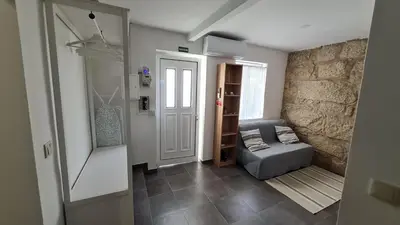 a living room with a couch and a stone wall at KirasHouse in Porto
