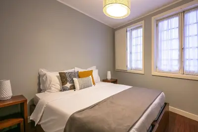 a bedroom with a large white bed with pillows at Stay In Apartments in Porto