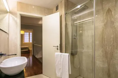 a bathroom with a glass shower and a sink at Stay In Apartments in Porto