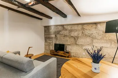 a living room with a couch and a stone fireplace at Stay In Apartments in Porto