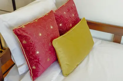 two red and yellow pillows sitting on a bed at OPORTO GUEST Oliveira House in Porto