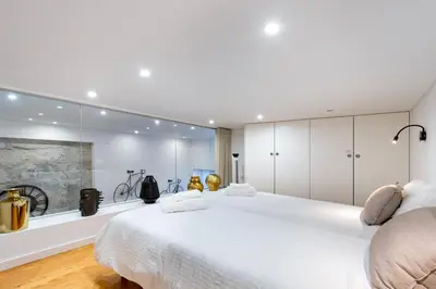 a bedroom with two large white beds and a large mirror at Majestic Cafe - Porto City Center Modern Apartment in Porto