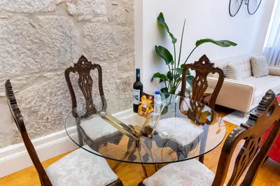 a glass table with two chairs and a bottle of wine at Majestic Cafe - Porto City Center Modern Apartment in Porto