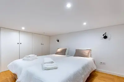 a white bedroom with a large white bed at Majestic Cafe - Porto City Center Modern Apartment in Porto