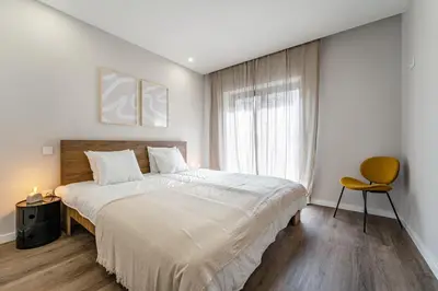 a bedroom with a large bed and a window at Nomad's Family - 2BED Casa da Música in Porto