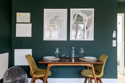 a dining room with green walls and a wooden table and chairs at Lóios 66 by LovelyStay in Porto