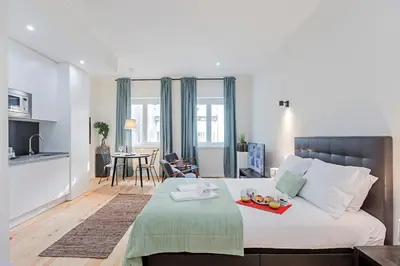 a bedroom with a bed with a tray of fruit on it at 150 Rivoli Apartments by LovelyStay in Porto