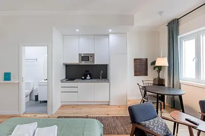a kitchen and living room with a table and chairs at 150 Rivoli Apartments by LovelyStay in Porto