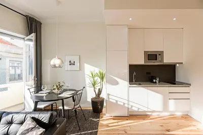 a living room with a table and a kitchen at 150 Rivoli Apartments by LovelyStay in Porto