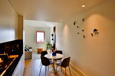 a dining room with a table and some birds on the wall at 4CITY FLAT CAMARÃO in Porto