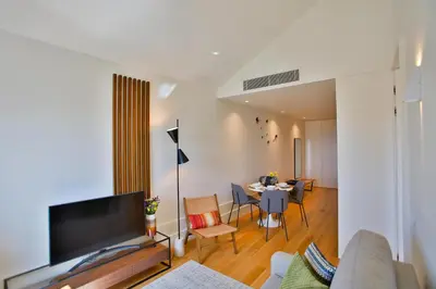 a living room with a couch and a table with chairs at 4CITY FLAT CAMARÃO in Porto