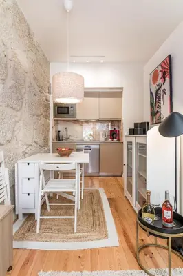 a kitchen with a white table and a white refrigerator at OPO Bonjardim 902 II in Porto