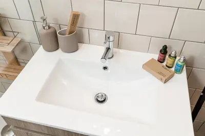 a white sink in a bathroom with bottles on it at OPO Bonjardim 902 II in Porto