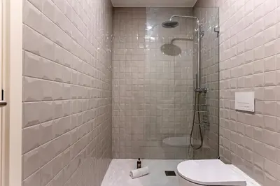 a bathroom with a shower and a toilet at 31 Janeiro 157 - Charming 1BR Flat w/ AC & Balcony by LovelyStay in Porto
