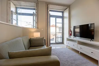 a living room with a couch and a flat screen tv at 31 Janeiro 157 - Charming 1BR Flat w/ AC & Balcony by LovelyStay in Porto