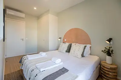 a bedroom with a large white bed with towels on it at 31 Janeiro 157 - Charming 1BR Flat w/ AC & Balcony by LovelyStay in Porto