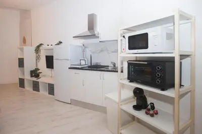 a kitchen with white cabinets and a microwave oven at Bonsai Apartment IIII in Porto
