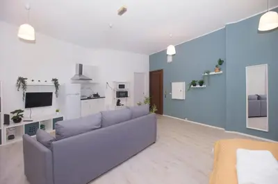 a living room with a gray couch and a blue wall at Bonsai Apartment IIII in Porto
