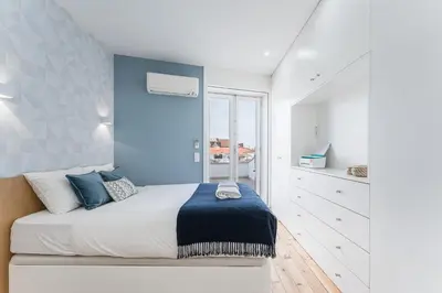 a bedroom with a bed with a blue wall at GuestReady - The Other Side in Porto