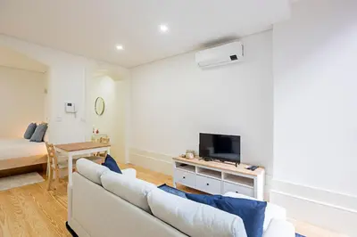 a living room with a couch and a tv and a bed at Casinha da Formosa by Oporto Soul in Porto