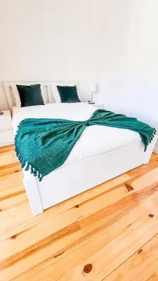 a white bed with a green blanket on it at Jardim do Morro Haus in Vila Nova de Gaia